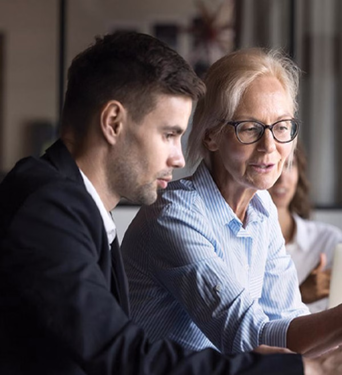Image of younger and older coworkers both looking at a screen