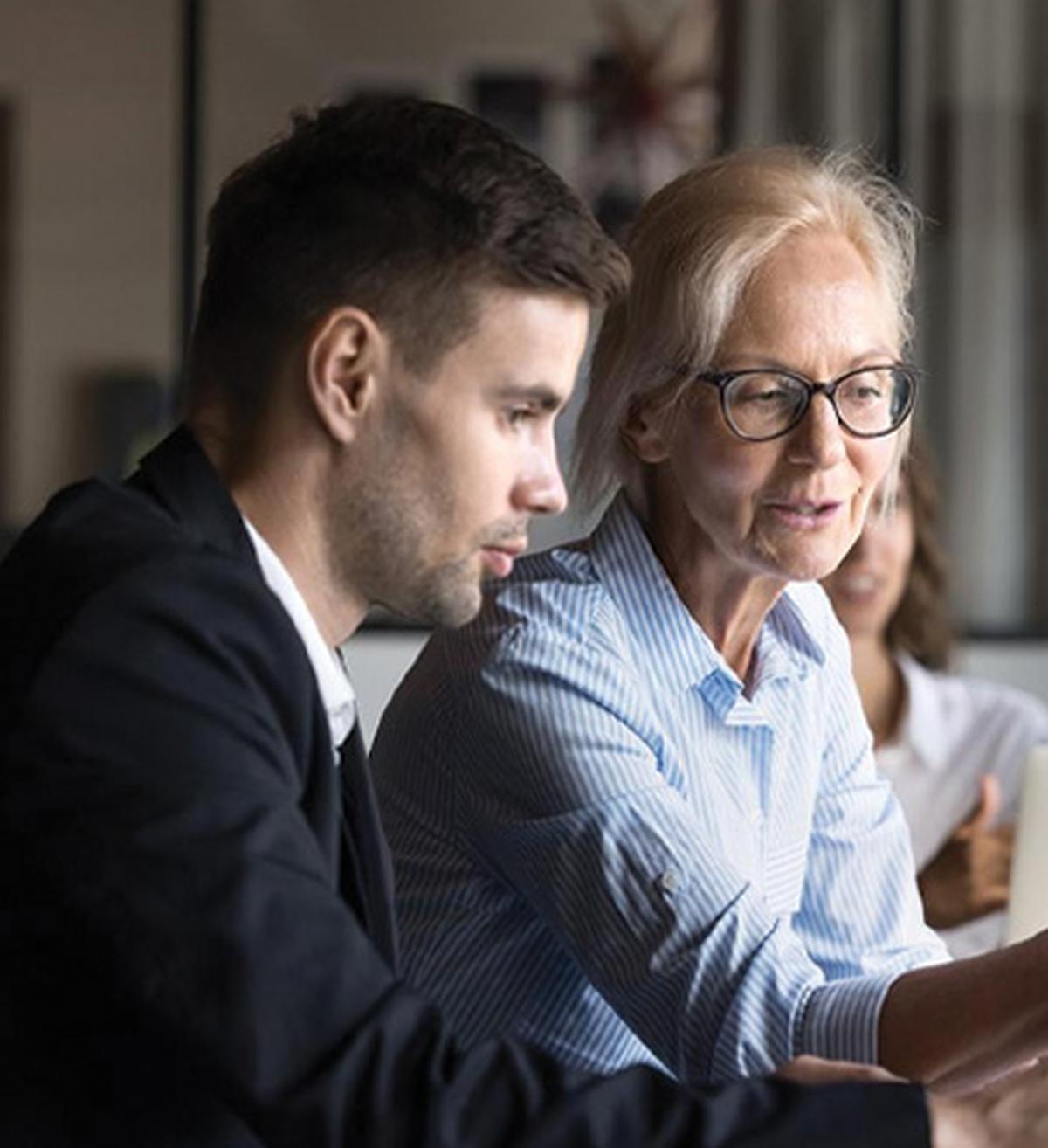 Image of younger and older coworkers both looking at a screen