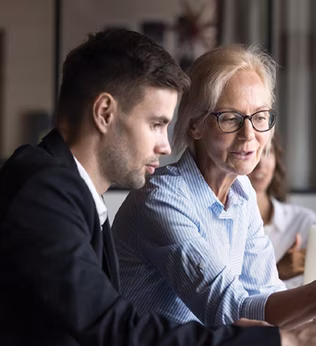 Image of younger and older coworkers both looking at a screen