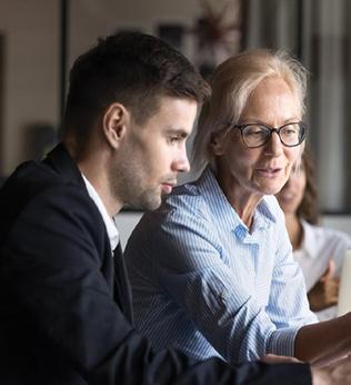 Image of younger and older coworkers both looking at a screen