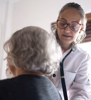 Photo of a doctor listening to a woman's back with a stethoscope