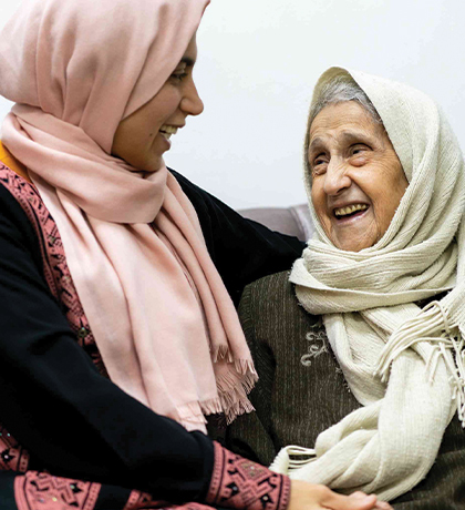 Photo of two women laughing and wearing headscarves