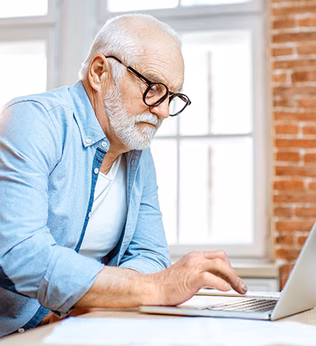 Photo of a man in a blue shirt using his laptop