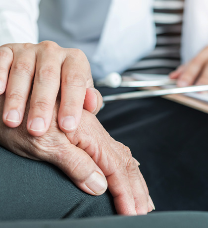 Image of a doctor's hand's resting on an elderly man's hands
