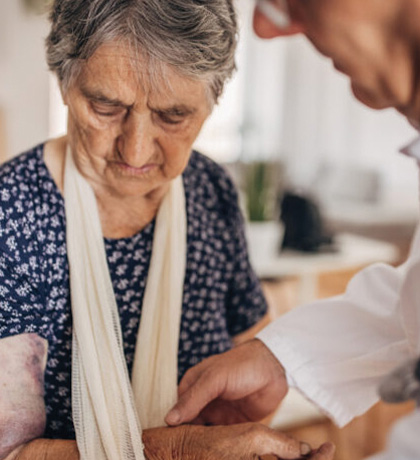 Image of an older woman in hospital being treated for an arm injury