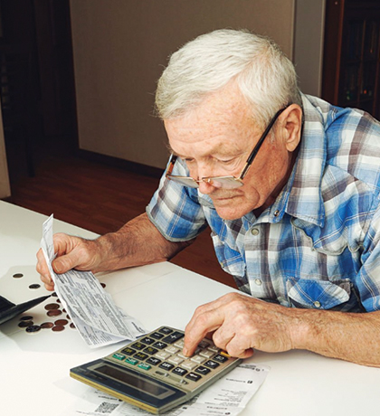 Photo of a man adding up bills with a calculator