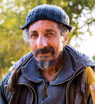 Photo of a man wearing layers of jackets and a knit cap