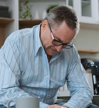 Photo of a man in a blue striped shirt sitting at a coffee table
