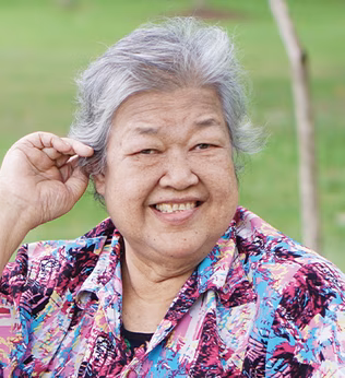 Photo of a woman in a blue and purple shirt smiling outdoors