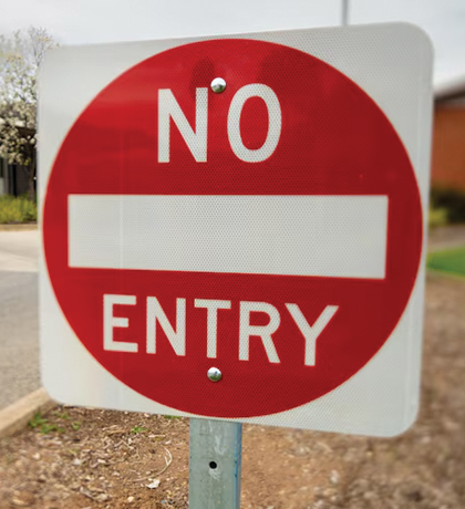 Photo of a no entry sign by a suburban roadside