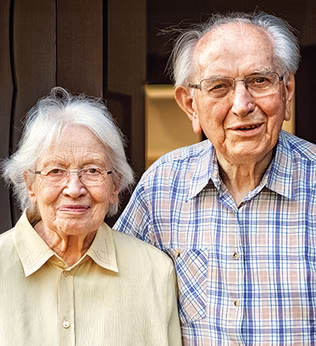 Photo of an older couple smiling at the camera