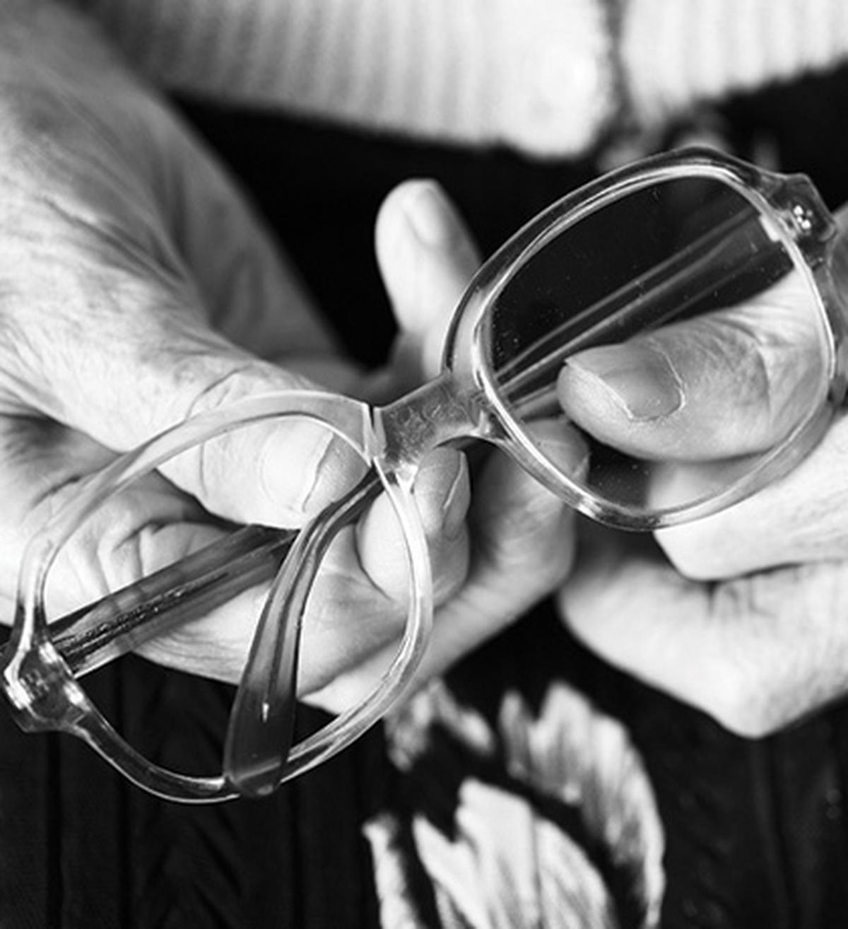 Image of an older person's hands holding some spectacles