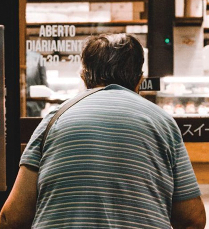 Photo of a stooped person entering a shop