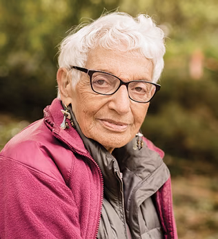 Photo of a woman in a magenta jacket sitting outside