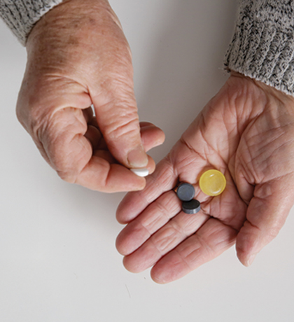 Photo of two hands holding a selection of pills