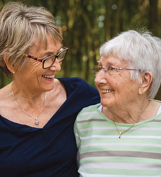 Photo of two women embracing and smiling at each other