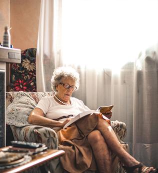 Image of an older woman reading at home