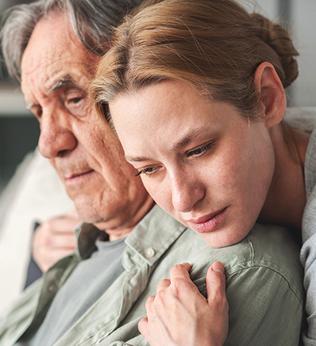 Photo of a young person embracing an older person