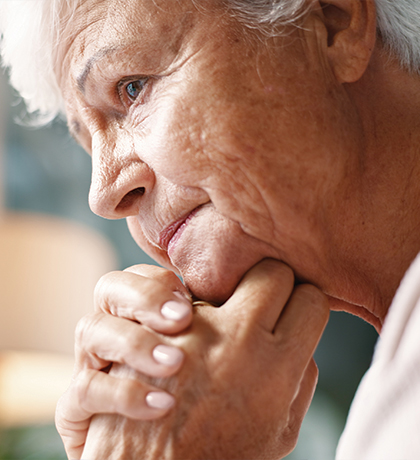 Photo of a woman resting her chin on her clasped hands