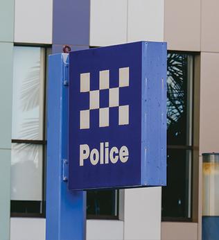 Photo of a blue police sign outside a building