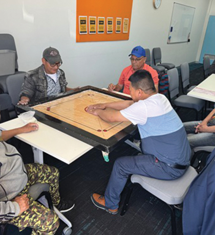 Group of people playing a boardgame around a table