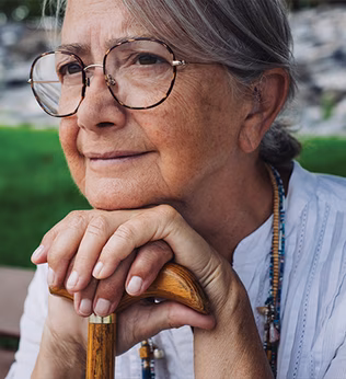 Photo of a woman wearing beads sitting on a park bench