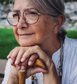 Photo of a woman wearing beads sitting on a park bench