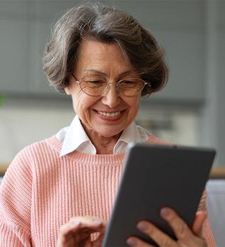 Image of an older woman looking at a tablet