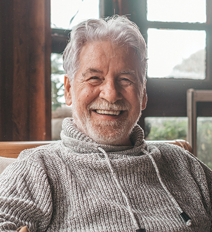 Photo of a smiling man in wearing a cosy grey knit