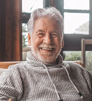 Photo of a smiling man in wearing a cosy grey knit