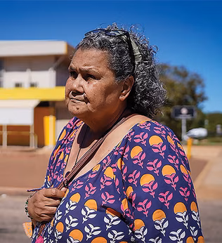 Photo of a woman wearing a purple dress outside a building