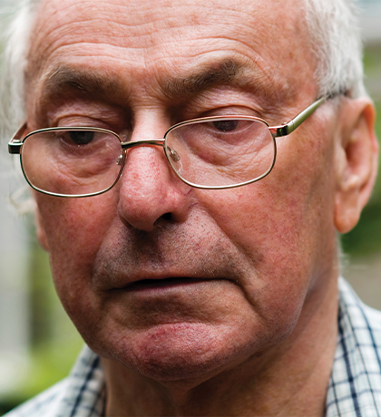 Photo of a man in a check shirt wearing spectacles