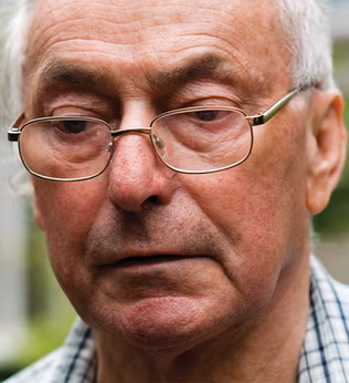Photo of a man in a check shirt wearing spectacles