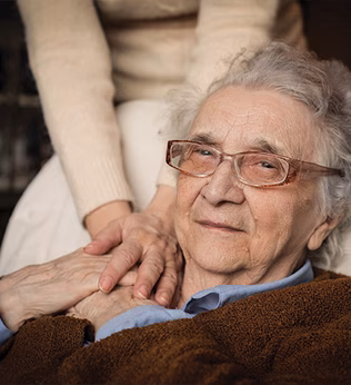 Photo of an older woman holding the hands of another person