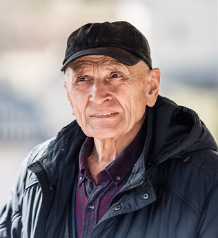 Photo of a person in a black puffer jacket and cap