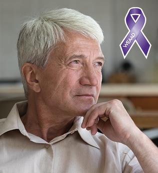Photo of man with white hair and pale shirt resting his chin on his hand