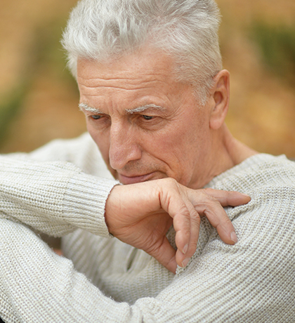 Photo of a man in a cream jumper looking pensive