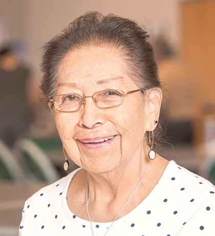 Photo of a smiling lady wearing a polka dot blouse