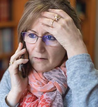 Photo of a woman with gold rings using a mobile phone