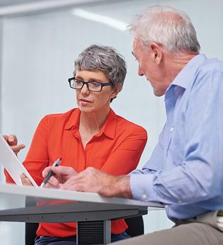 Photo of a woman in an orange shirt and a man wearing blue
