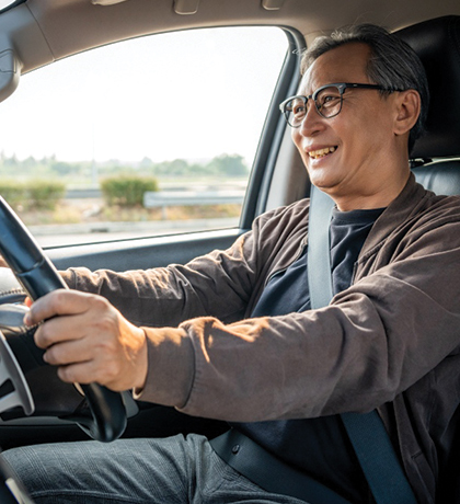 Photo of a smiling man behind the steering wheel of a car