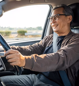 Photo of a smiling man behind the steering wheel of a car