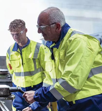 Photo of two men wearing high vis at an engineering plant