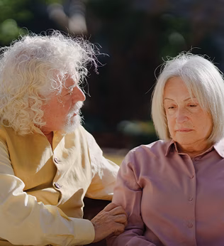 Photo of two people with white hair sitting on a park bench