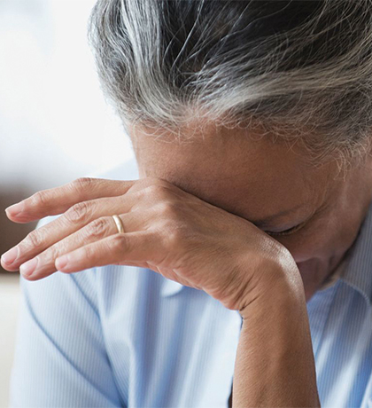 Photo of a woman resting her forehead on the back of her hand