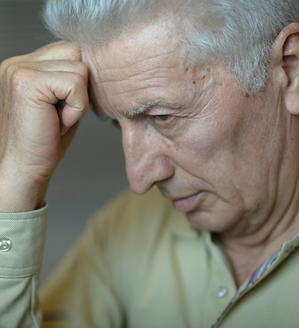 Photo of a man resting his forehead on his fist