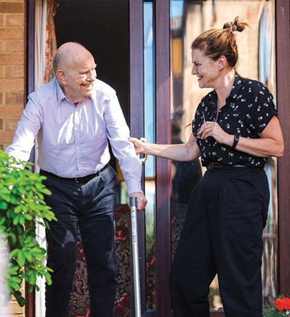 Photo of a man and woman smiling in a courtyard