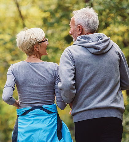 Photo of a fit older couple walking through a park