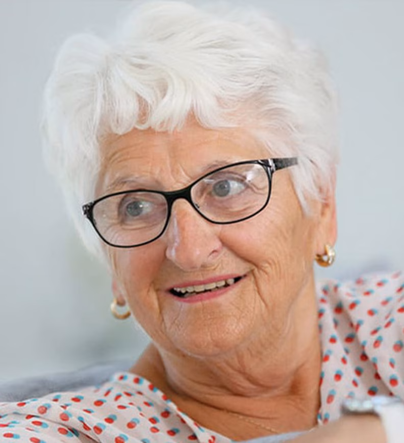 Photo of a white haired woman wearing black framed glasses