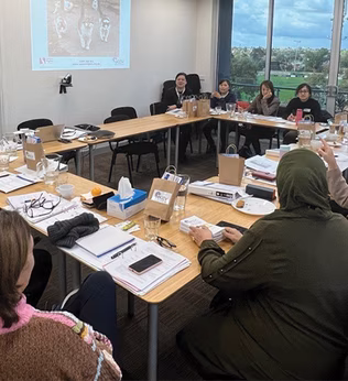 Photo of people sitting in a conference room meeting